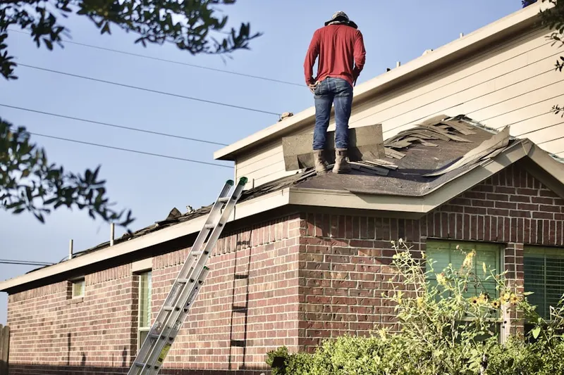 Professional roofer working on a residential roof in East Milton